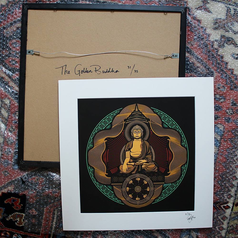 Framed artwork of the Buddha with intricate patterns in green, gold, and black, and a white border, resting on a patterned carpet.