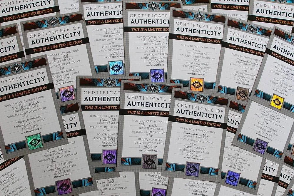 Multiple certificates of authenticity with a black, orange, and blue design, each featuring a holographic sticker and a signature.