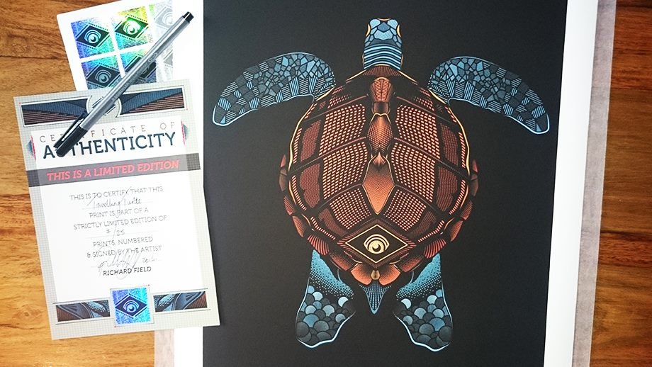 A colorful digital illustration of a turtle on black paper, with detailed patterns and geometric designs, accompanied by a certificate of authenticity, pen, and a sheet of holographic stickers on a wooden surface.