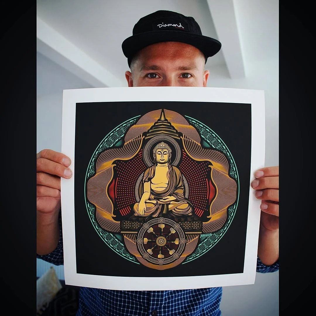 Person holding a colorful, stylized artwork of Buddha in a meditative pose, with intricate circular patterns and decorative elements, against a black background.