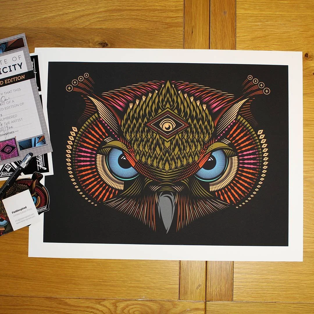 A colorful, stylized illustration of an owl with large blue eyes and intricate patterns on a black background.