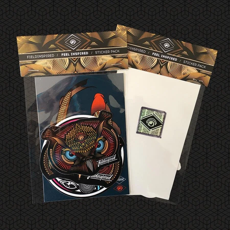 Collection of stickers and patches with eye and owl designs, inside sealed plastic packaging with decorative black and gold borders.