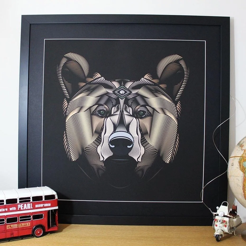 A framed, digital-style artwork of a wolf's face on a black background. The wolf's face is detailed with various shading techniques, including lines and geometric shapes, creating a stylized, modern appearance. On the lower left, there is a small dec