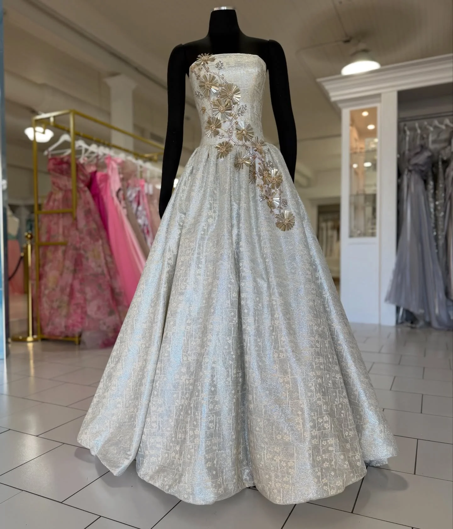 A constellation of champagne light ✨
Hand-embroidered florals bloom across a luminous corset, each petal catching the glow like spun gold. This one-of-a-kind gown exists only once, crafted to shimmer, sculpt, and never be repeated. #prom #prom2026 #p