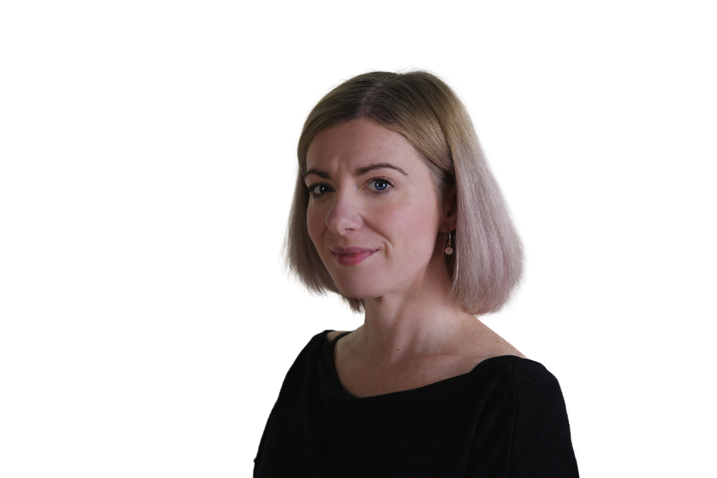 A woman with shoulder-length blond hair, blue eyes, wearing a black top and earrings, looks at the camera with a slight smile.