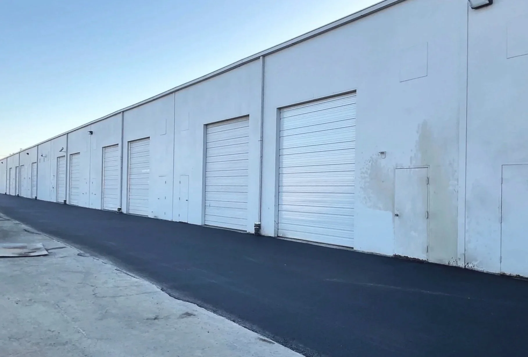 New asphalt paving installed after utility upgrades and grading at Space Center commercial redevelopment project