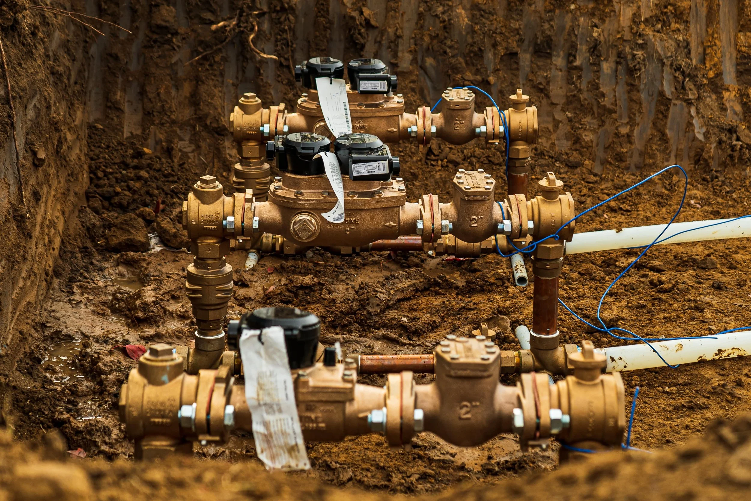 Three newly installed water meters on a job site