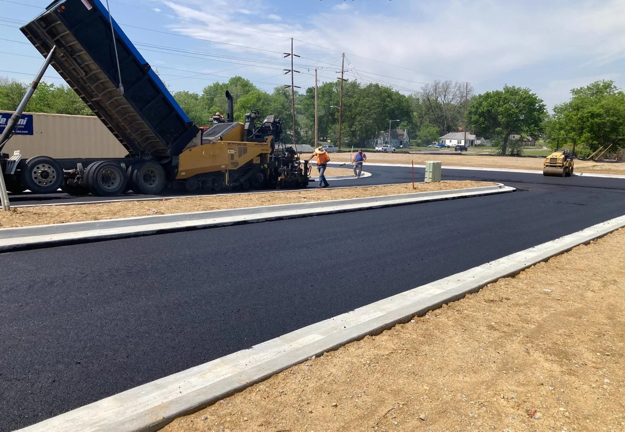 Asphalt paving operations for new residential street during Black Wall Street Square neighborhood development in Tulsa Oklahoma