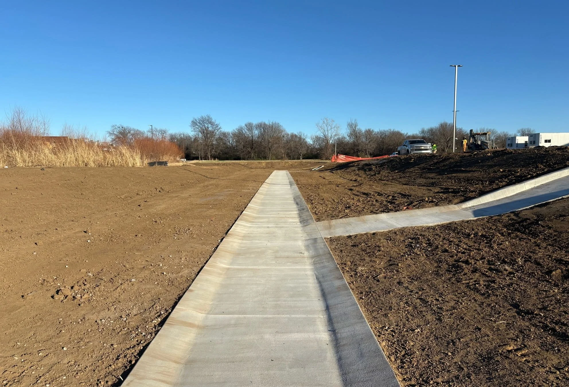 New concrete sidewalk and final grading installed as part of site development for Academy Sports and Outdoors in Muskogee Oklahoma
