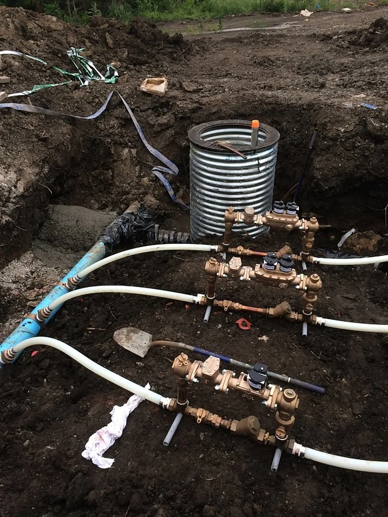 Multiple water meter assemblies installed underground during utility installation.