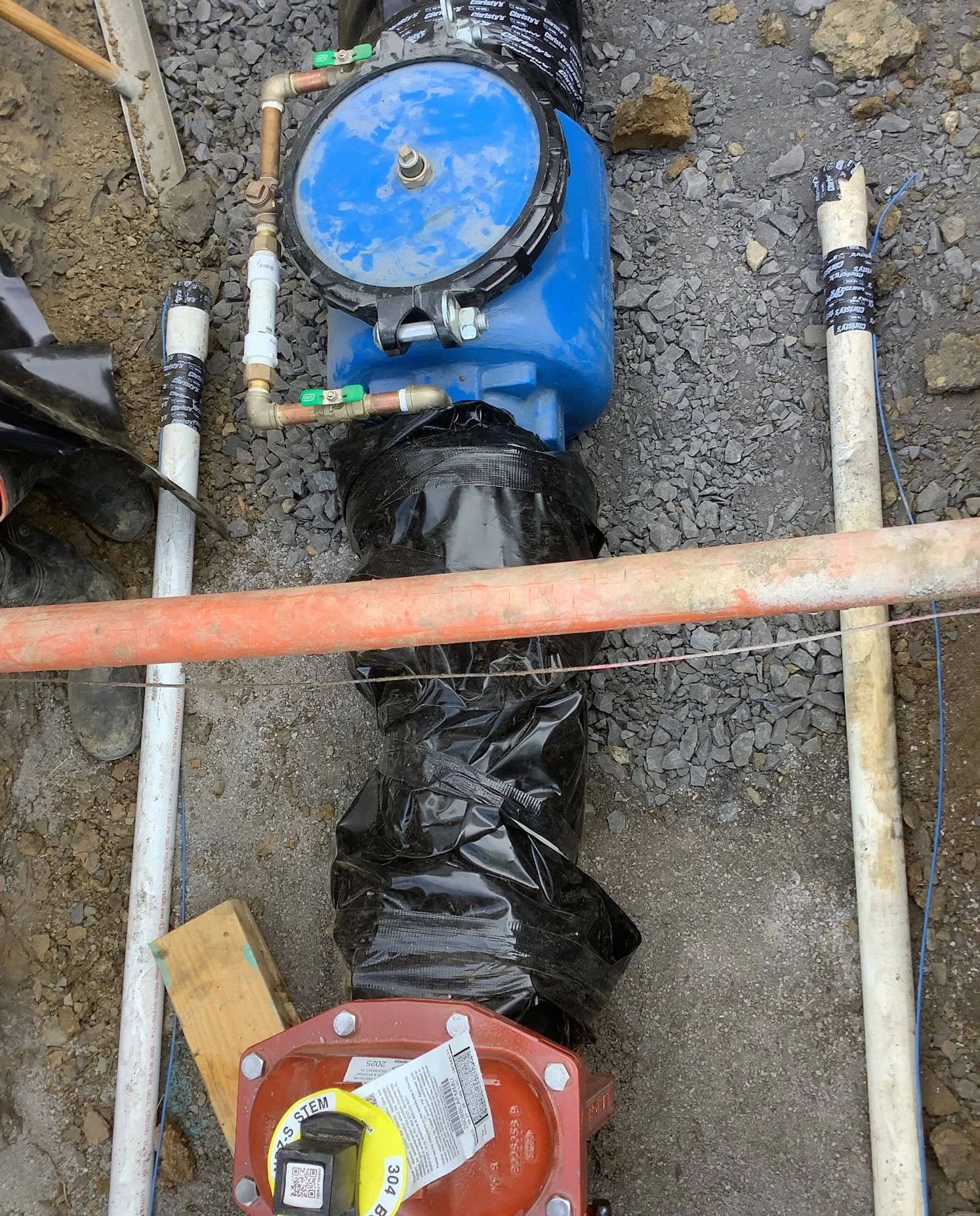 Underground waterline installation with meter and piping during utility construction at Academy Sports and Outdoors site in Muskogee Oklahoma