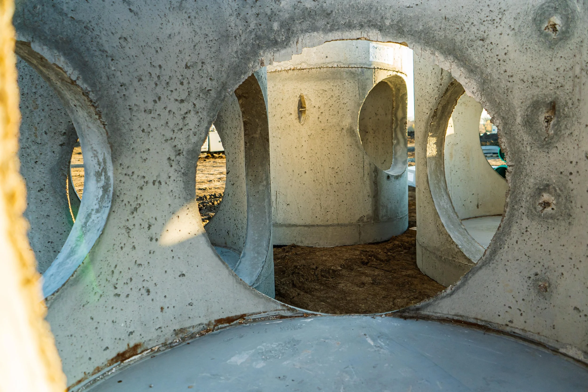 Precast concrete manhole sections with access openings on job site