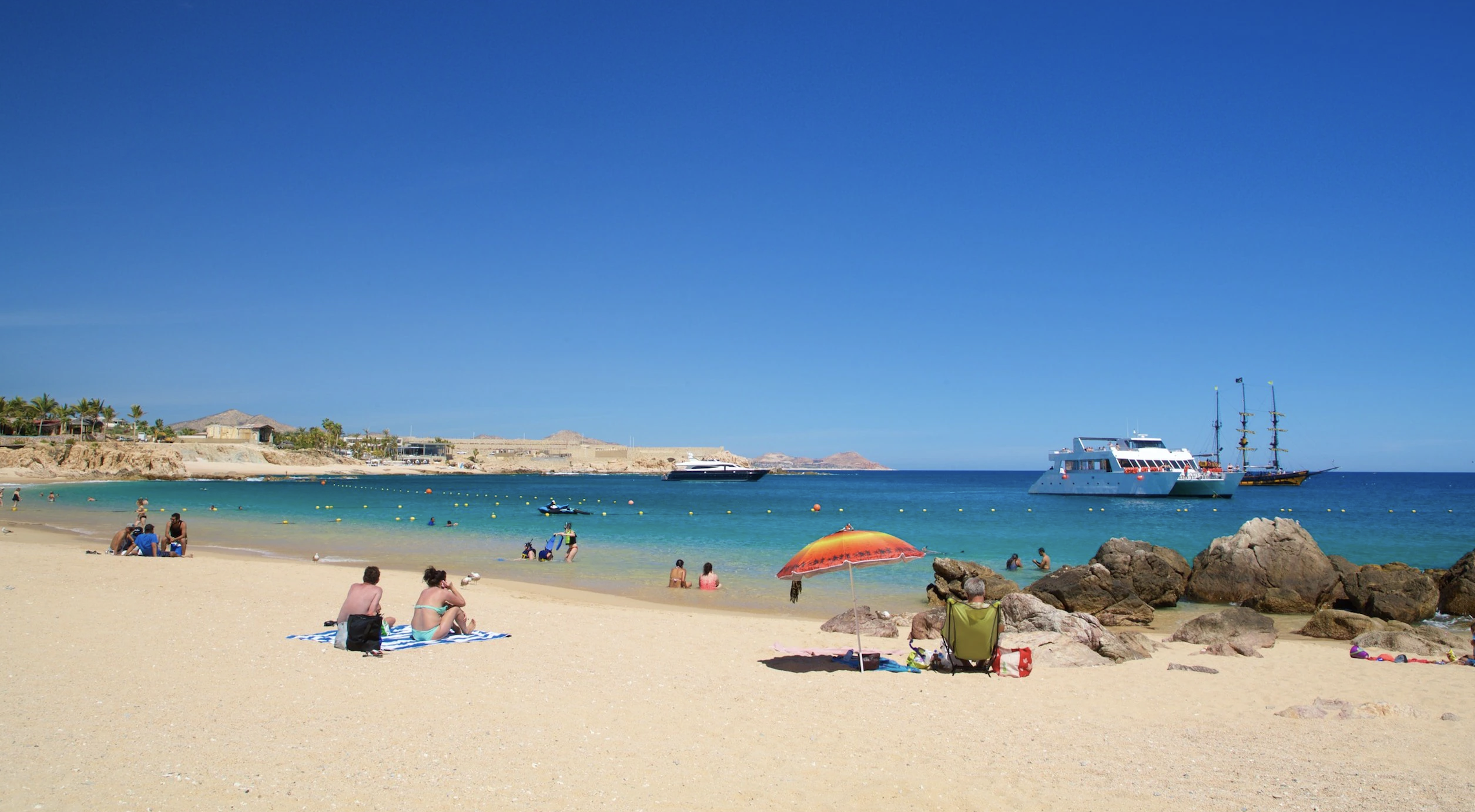 People on Chileno Beach relaxing under their umbrellas fun in the sun vacation rentals in mexico 5 star 