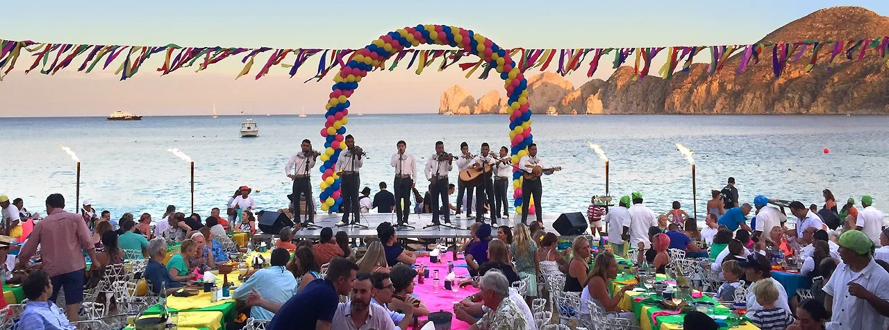 A photo of a bank playing at an event lookin out on the sunset waters of the arch in Cabo San Lucas Mexico 