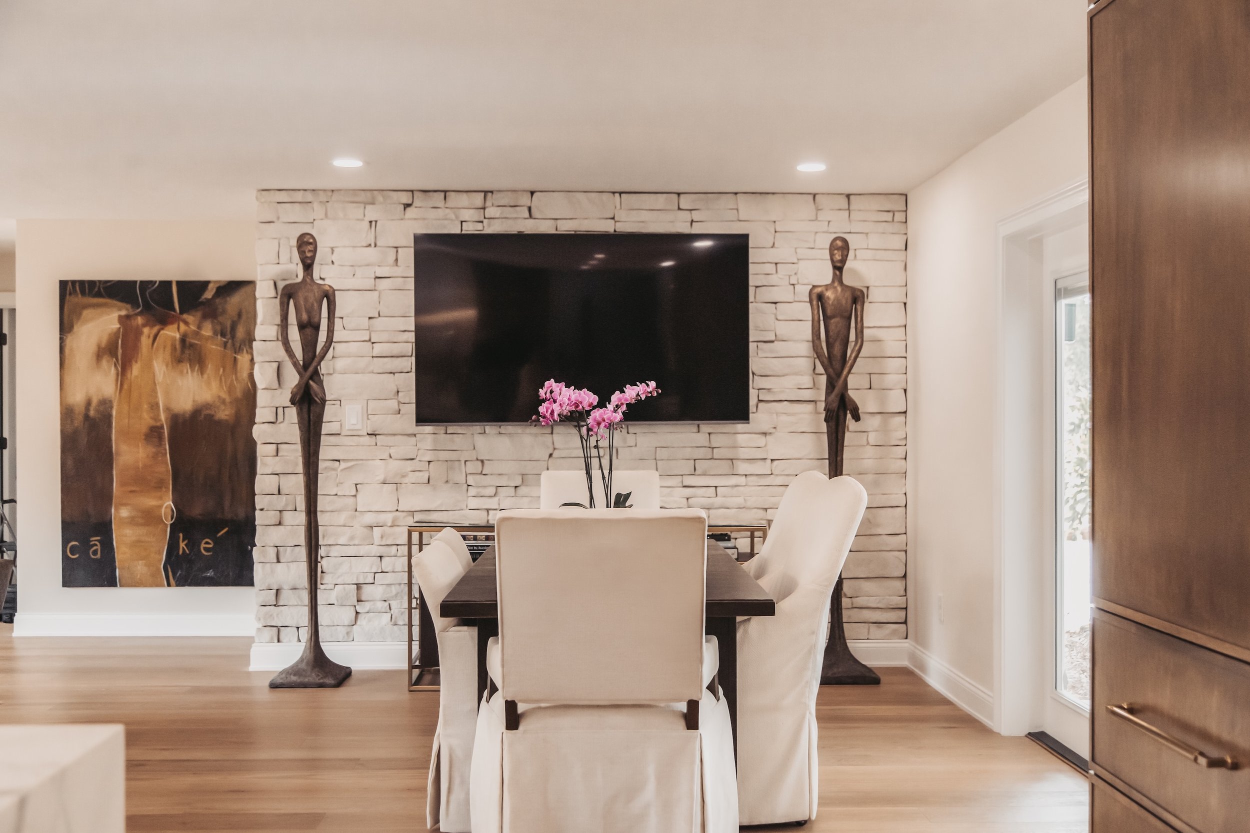 whitewashed stone wall with unique statues in front