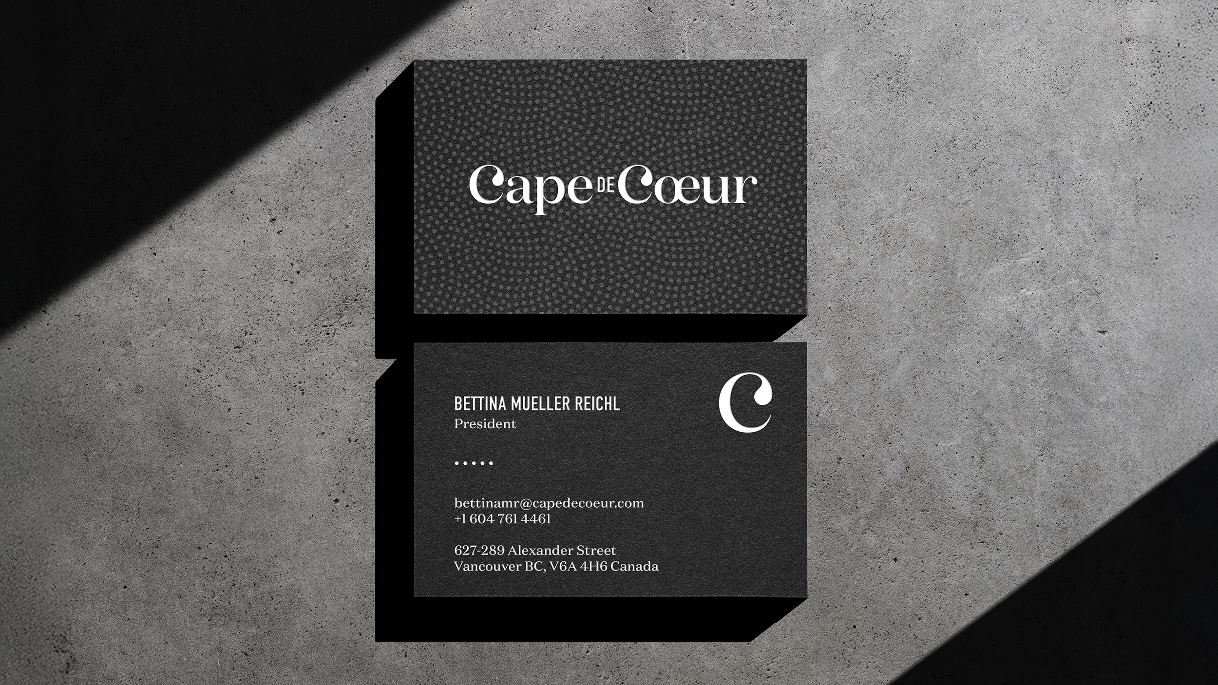 Design of Cape de Coeur business cards with white text of black paper.