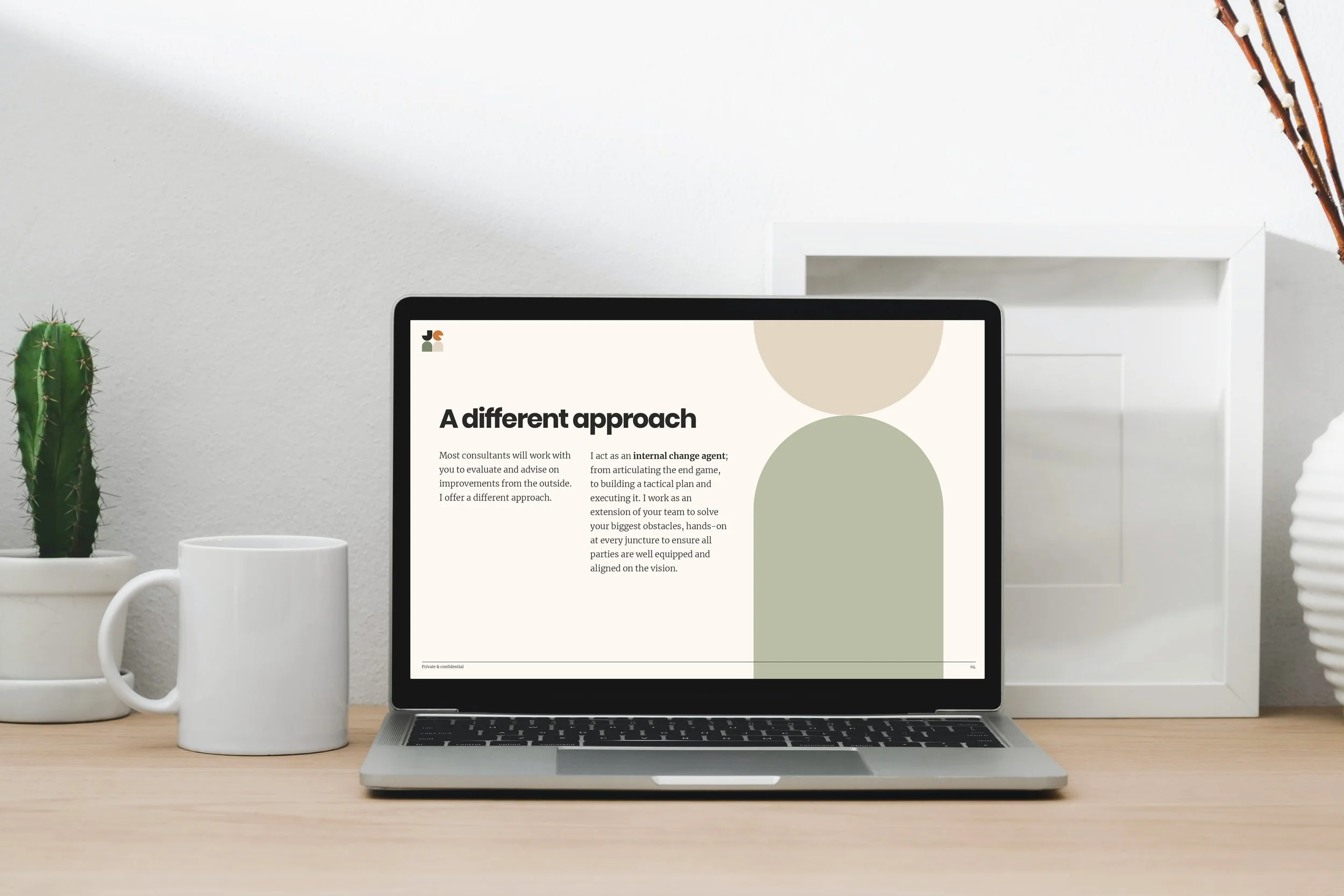 Laptop displaying a presentation titled 'A different approach' on a light-colored desk with a white mug, potted cactus, and white decorative box; minimalistic interior with neutral tones.