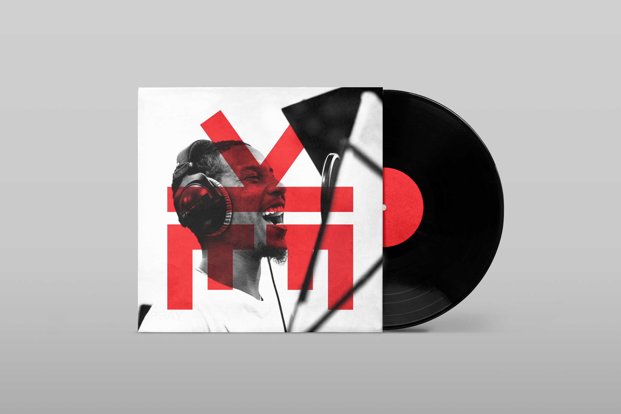Vinyl record with album cover showing a black and white photo of a man singing into a microphone, wearing headphones, with red abstract shapes overlaying the image.