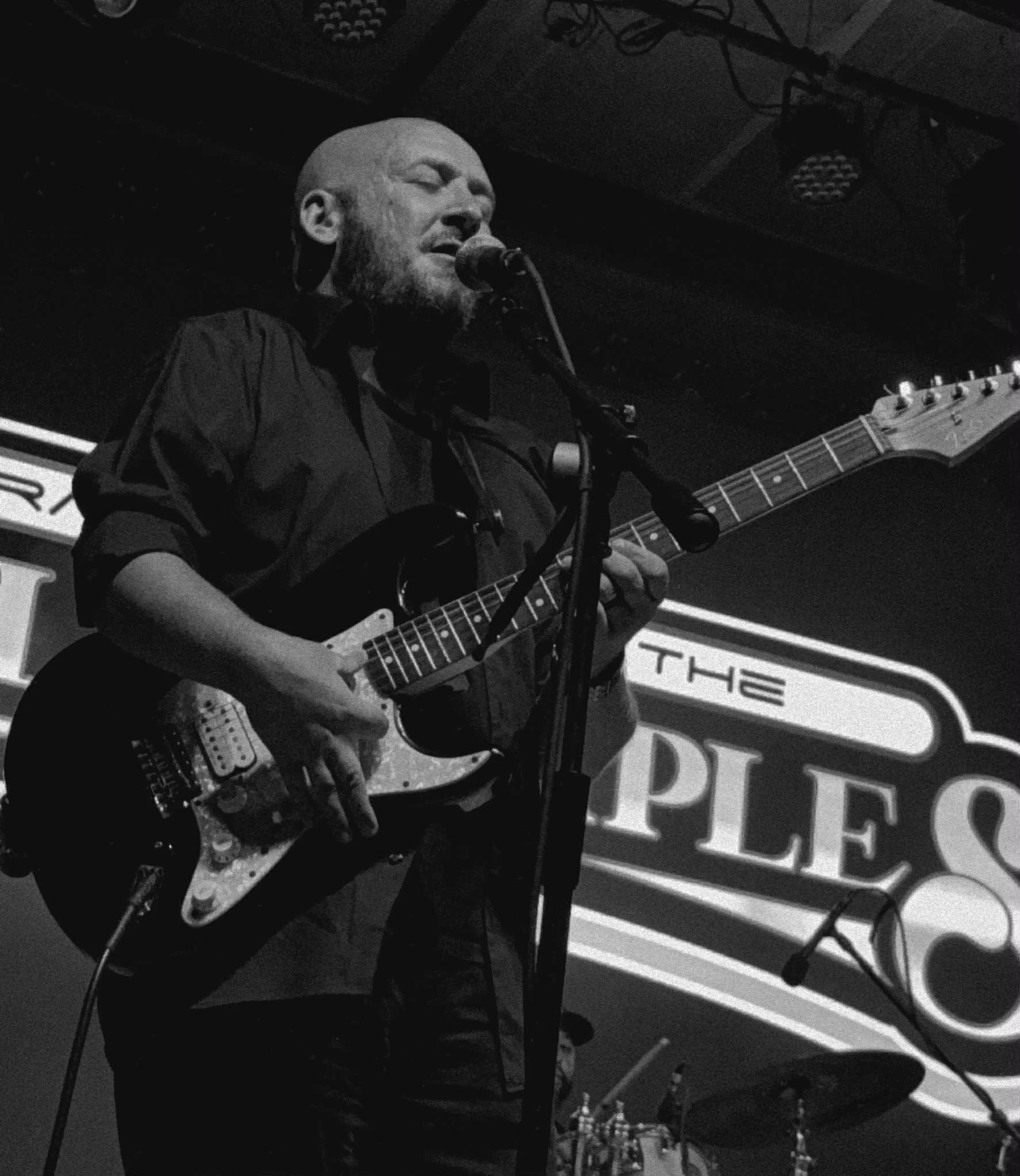 Dara James performing live on stage, singing into a microphone