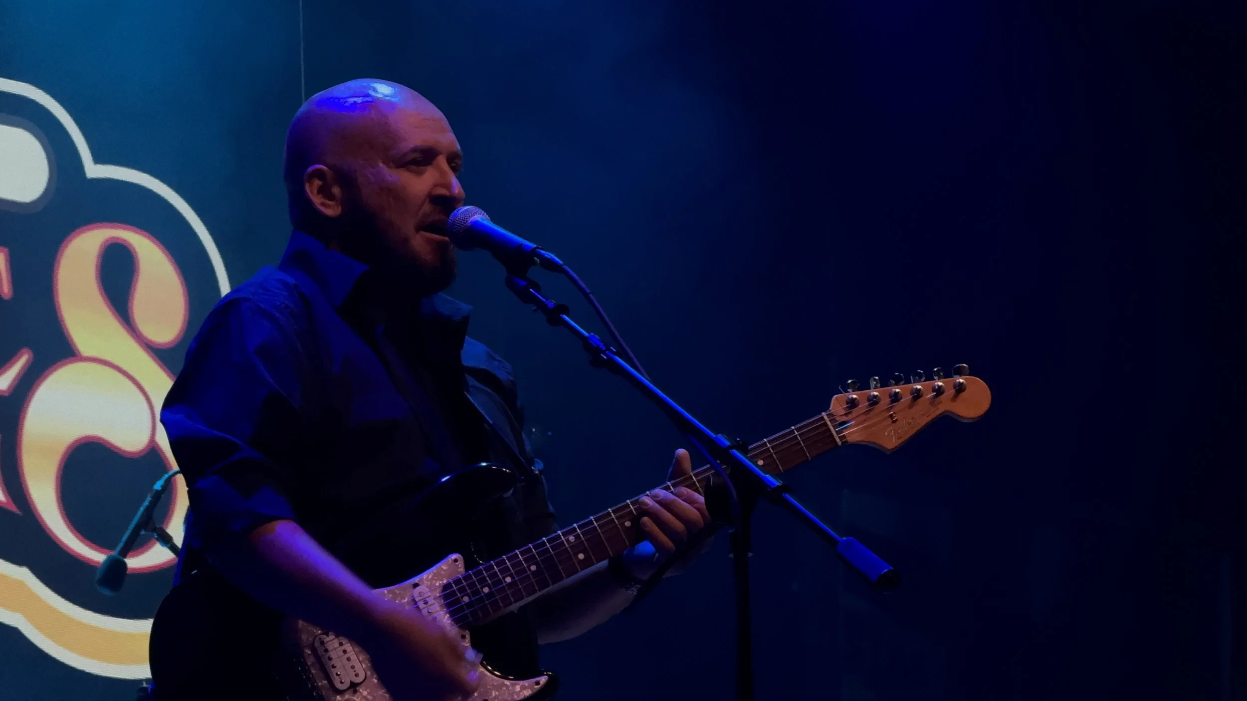 Dara James performing live on stage, singing into a microphone