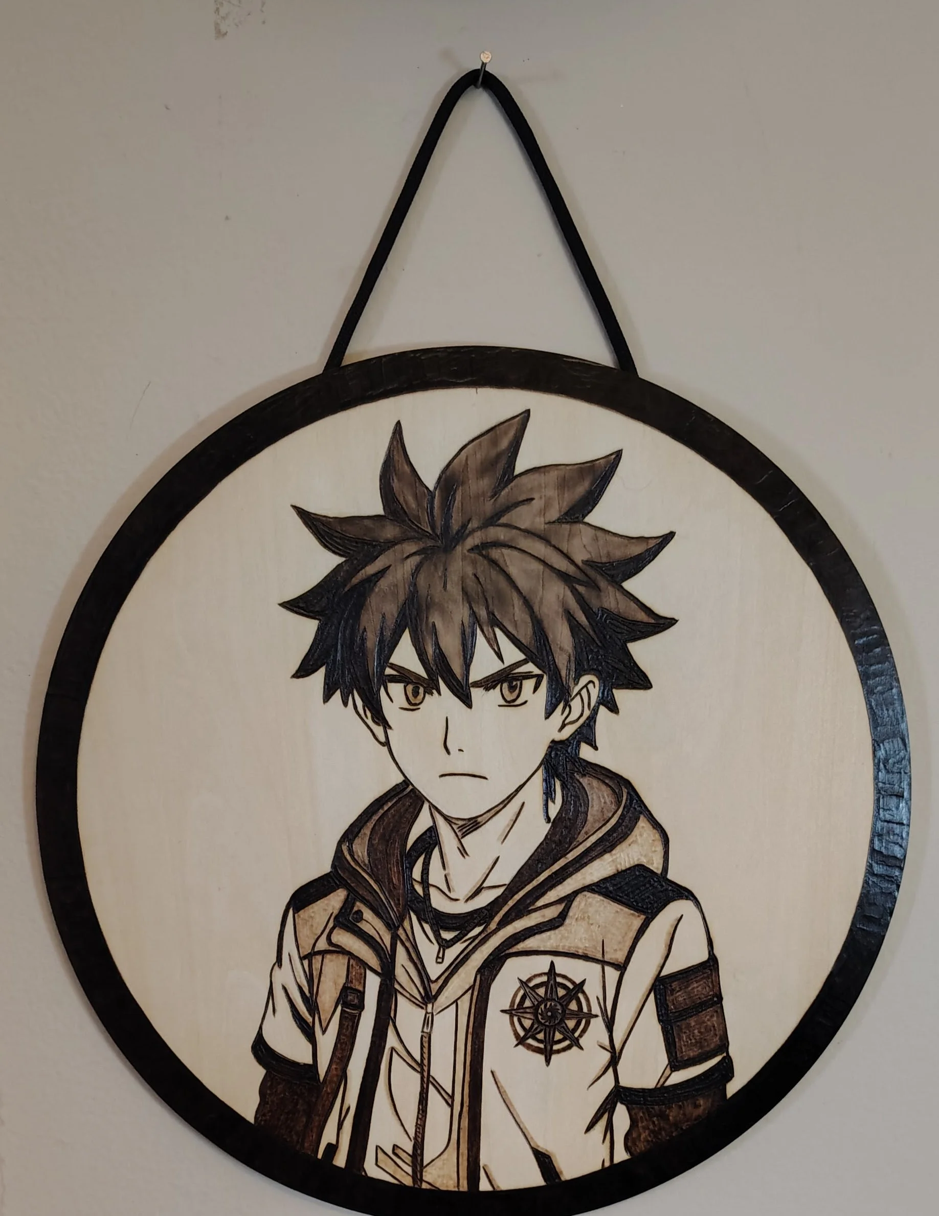 Illustration of a young male anime character with spiky dark hair, wearing a jacket with a compass rose emblem, and a serious expression, on a round wooden plaque hanging on the wall.