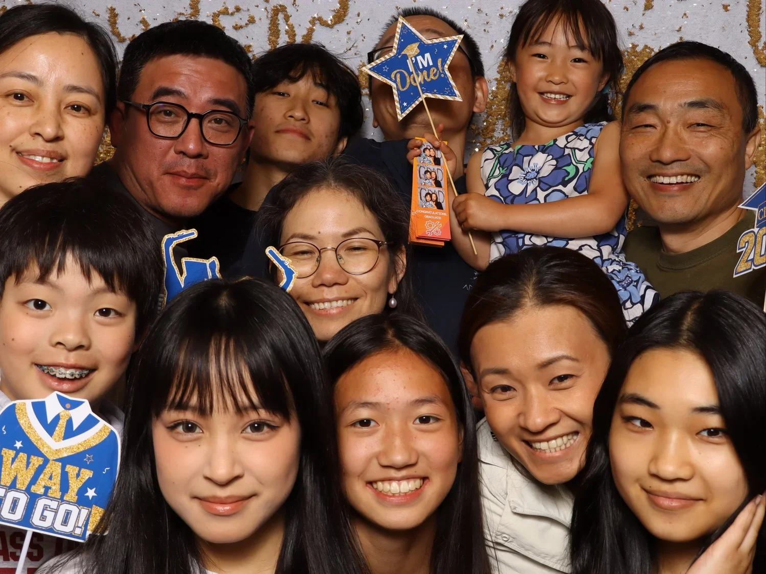 Group of people celebrating a graduation, holding signs and photo booth props. Lightning Booth Photo Booth.