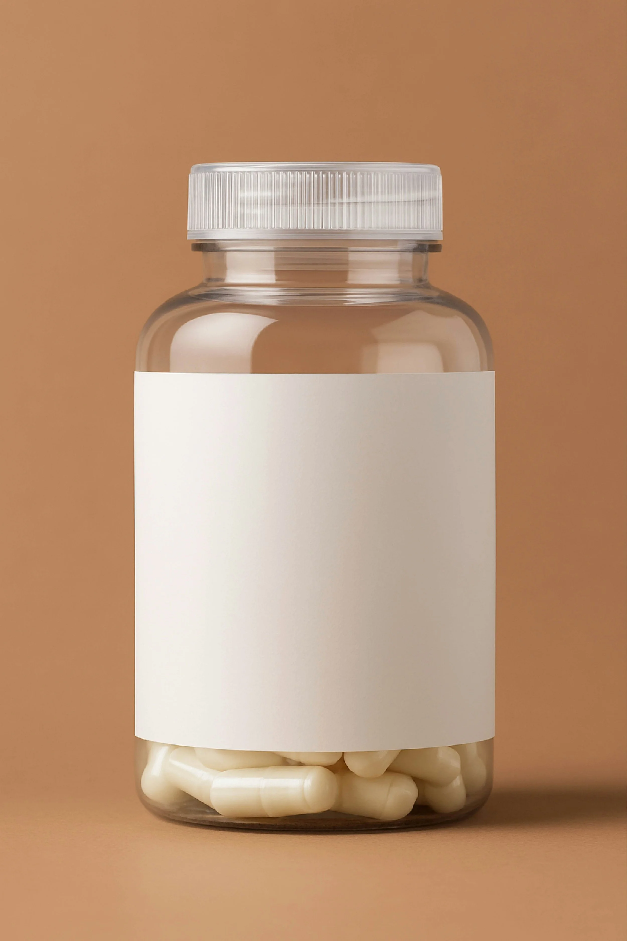A clear plastic bottle with a white cap, containing white capsules, against a beige background, and a blank white label on the front.
