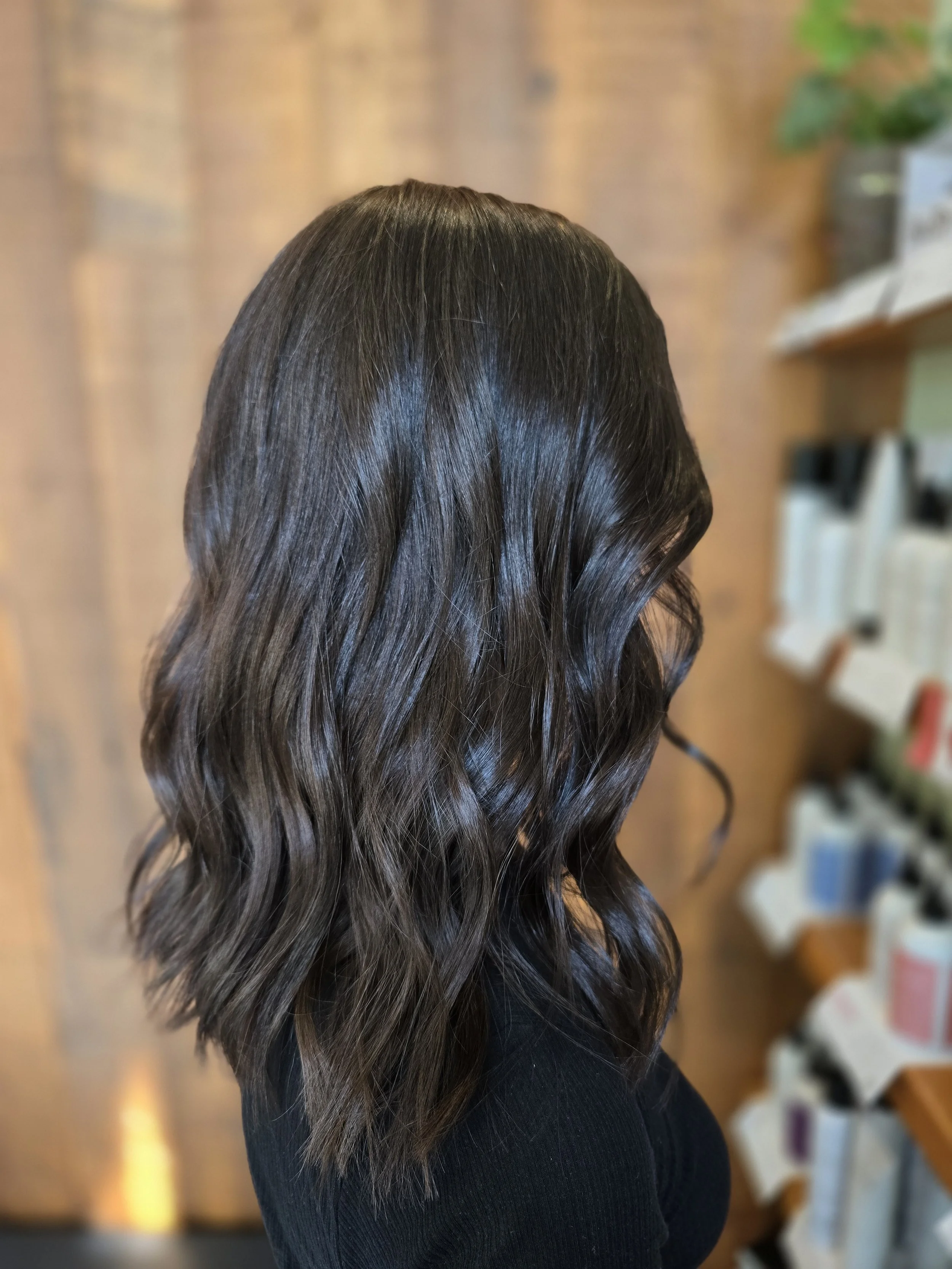 Woman with shoulder-length, wavy, dark brown, multi-tonal colour. 
