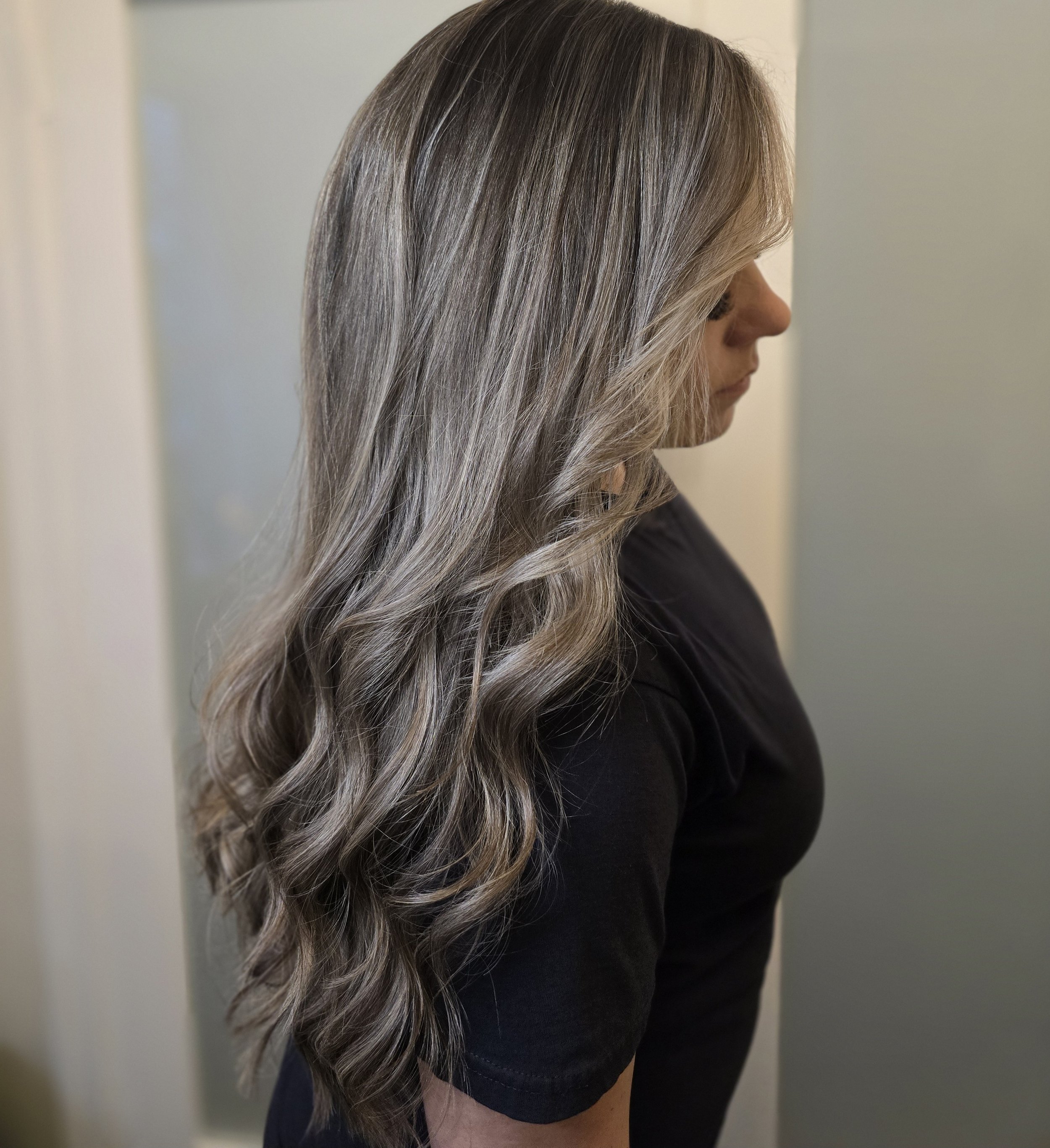 Woman with long, wavy, cool-blonde hair in a clean, home-based studio in Surrey, BC.