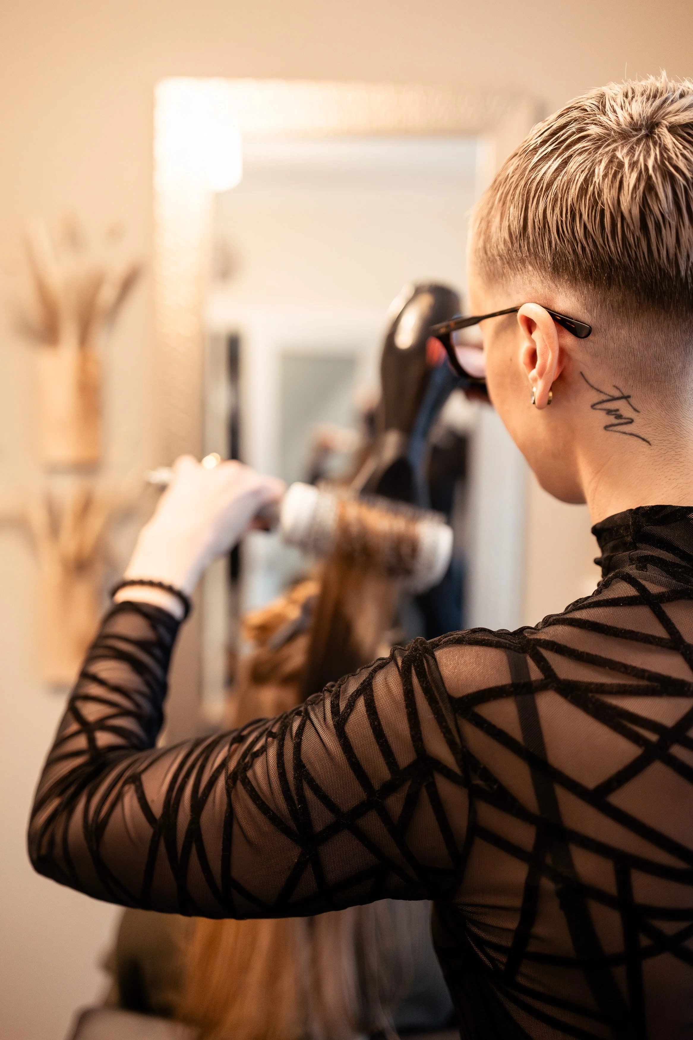 Expert hair colourist drying her lived-in blonde hair colour in her home studio in Surrey, BC Canada