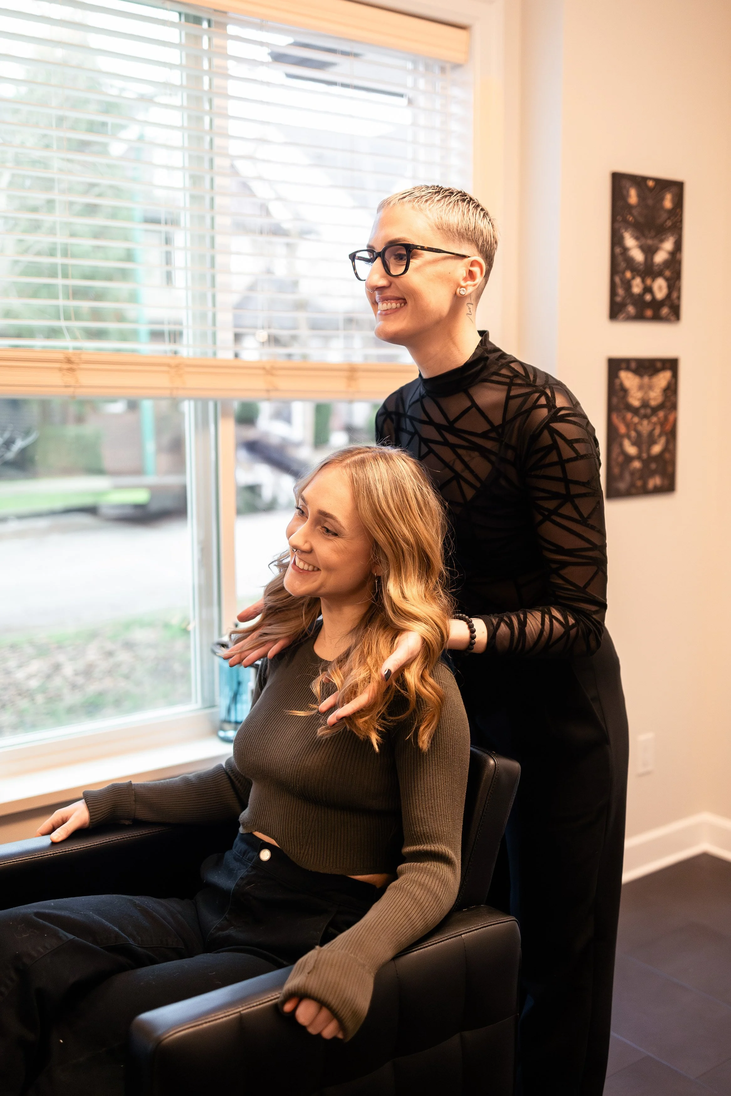 Master stylist checking her cut and styling with her blonde client in a well-lit studio in Surrey BC.