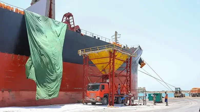 Port infrastructure in Djibouti with a large cargo vessel, truck and industrial equipment, illustrating Cognitra Group’s analysis of how infrastructure, skills and institutional pathways shape access to economic opportunity and social mobility.