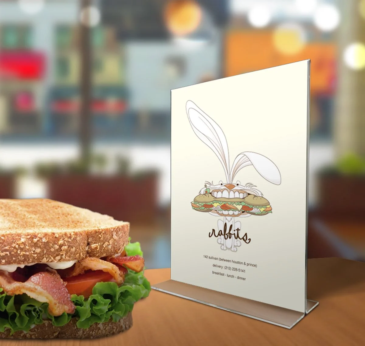Close-up of a sandwich with a menu stand featuring a cartoon bunny with a sandwich in its mouth.