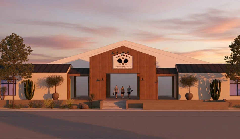 The exterior of a pickleball club building at sunset with a group of three people walking out of the entrance, featuring desert plants and cacti in the landscaping.