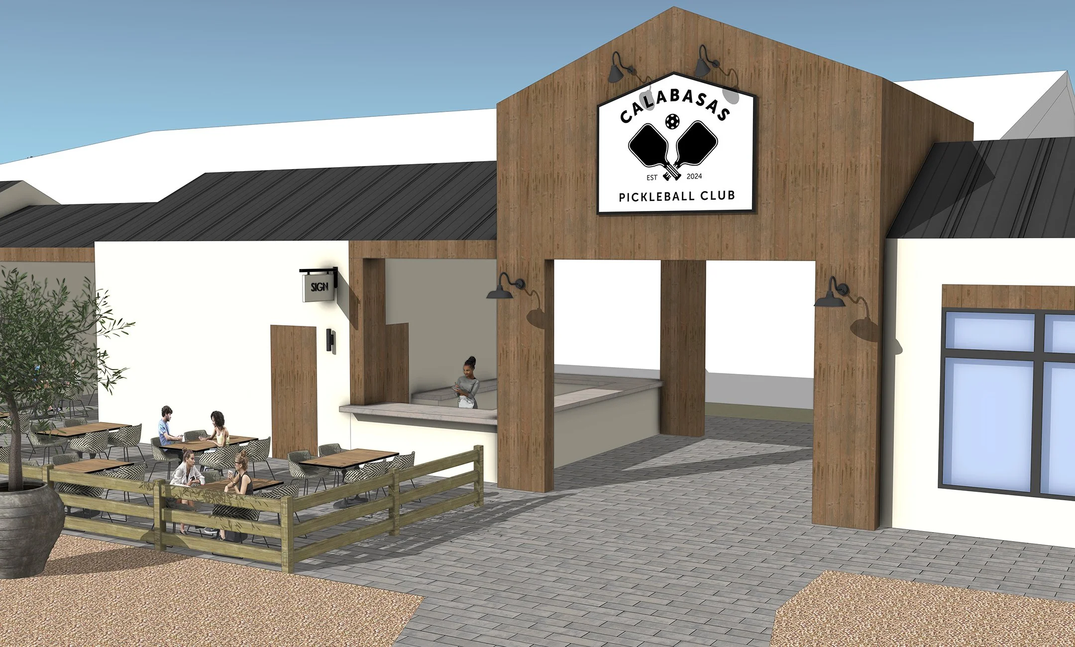 Exterior view of Calabasas Pickleball Club with a large sign, outdoor seating area, and building entrance.
