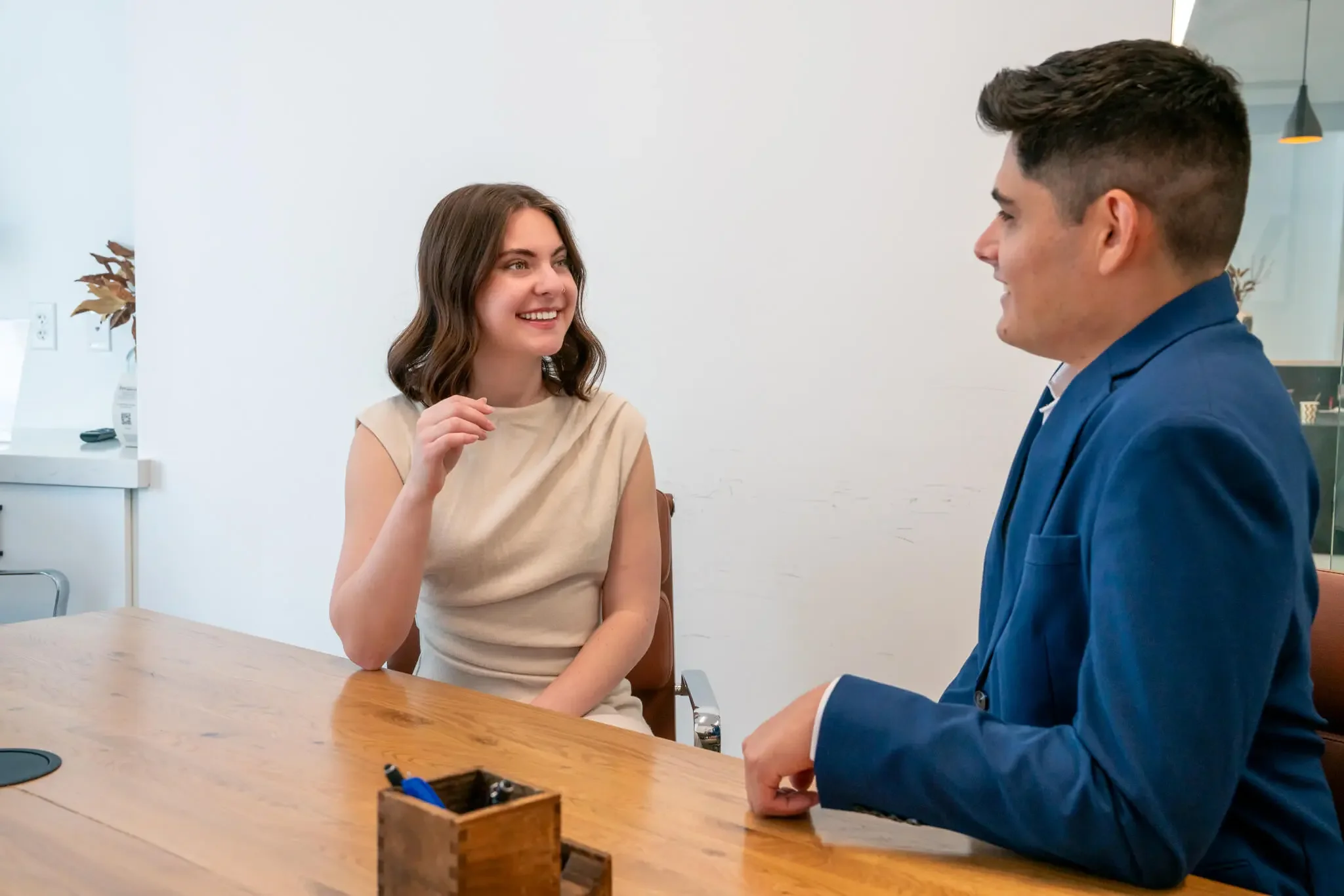 A real estate agent from Bryant Real Estate conducting a friendly consultation with a client at a wooden conference table in a bright Phoenix office.