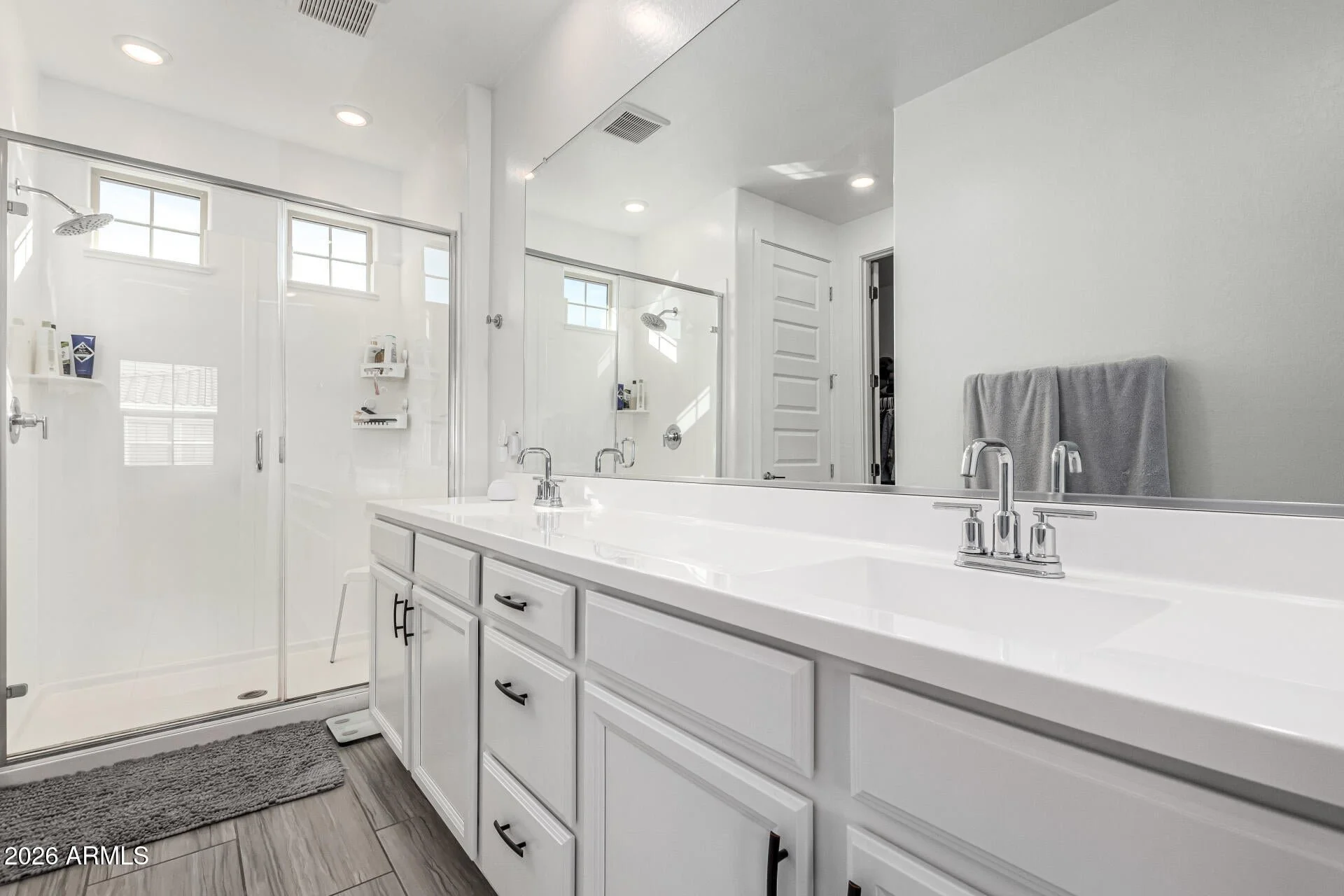 Modern ensuite bathroom in a Chandler, Arizona home for sale featuring dual sinks, walk-in shower, contemporary fixtures, and clean, neutral finishes