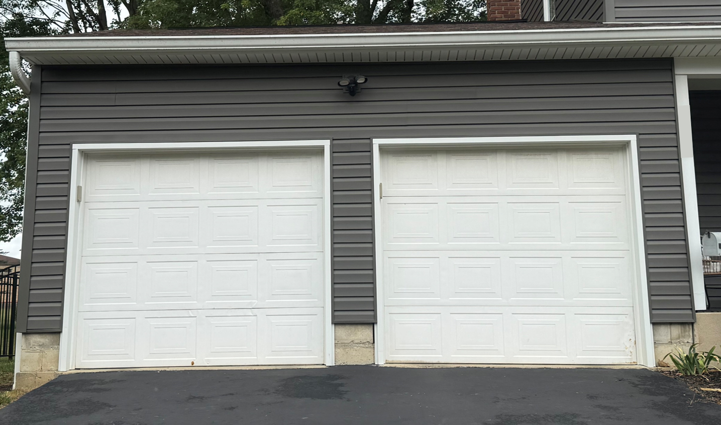 Before Replacement: Two side-by-side white 8-by-8 foot garage doors