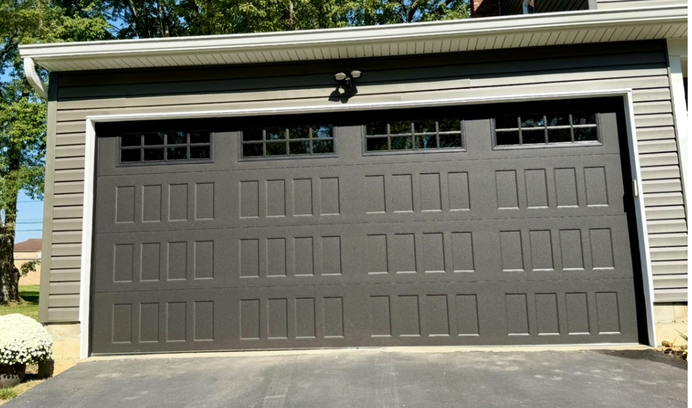 After Replacement: Single grey 18-by-8 foot garage door with windows in the top section