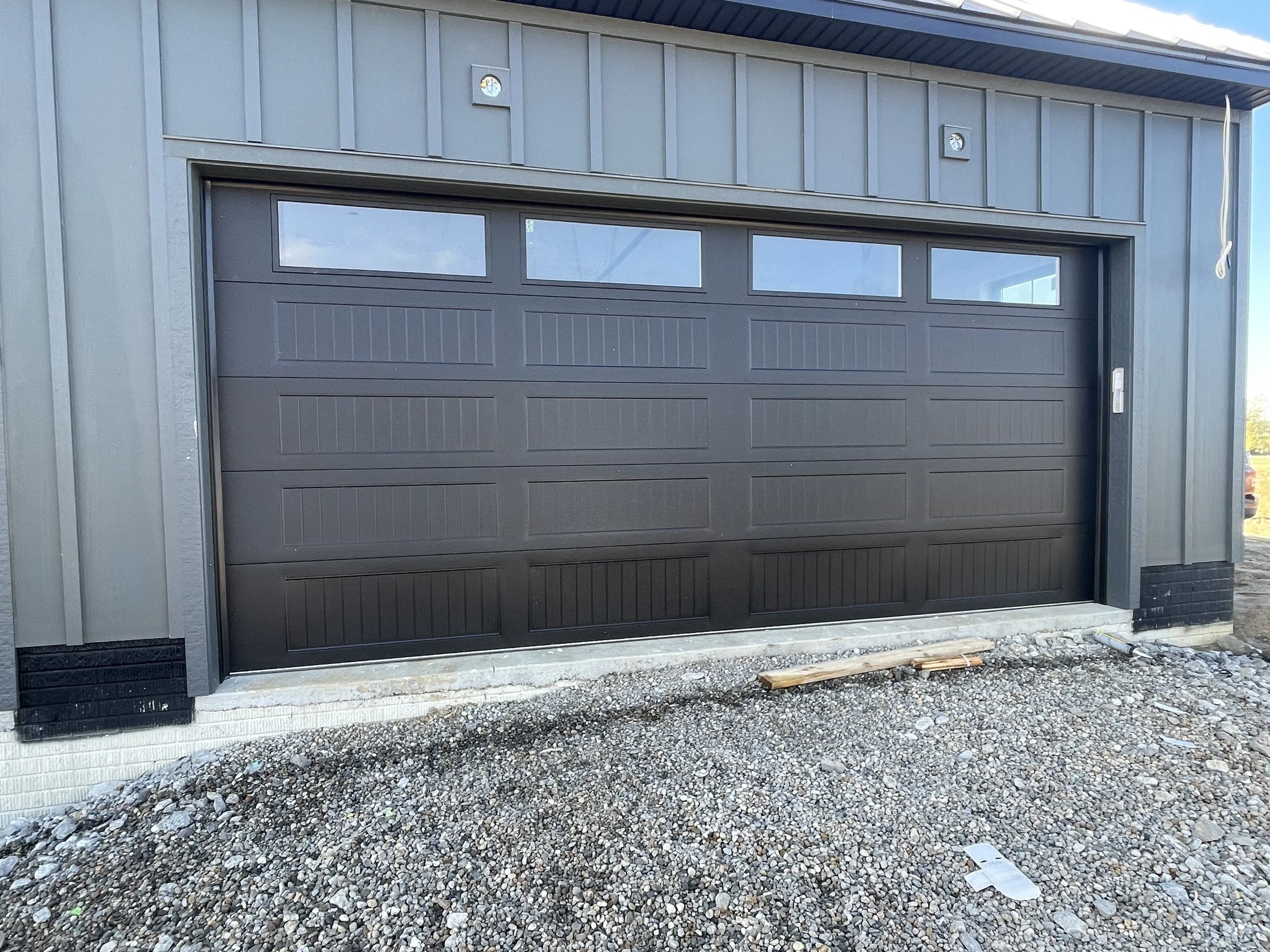 Black 18 foot garage door with 4 windows across the top section