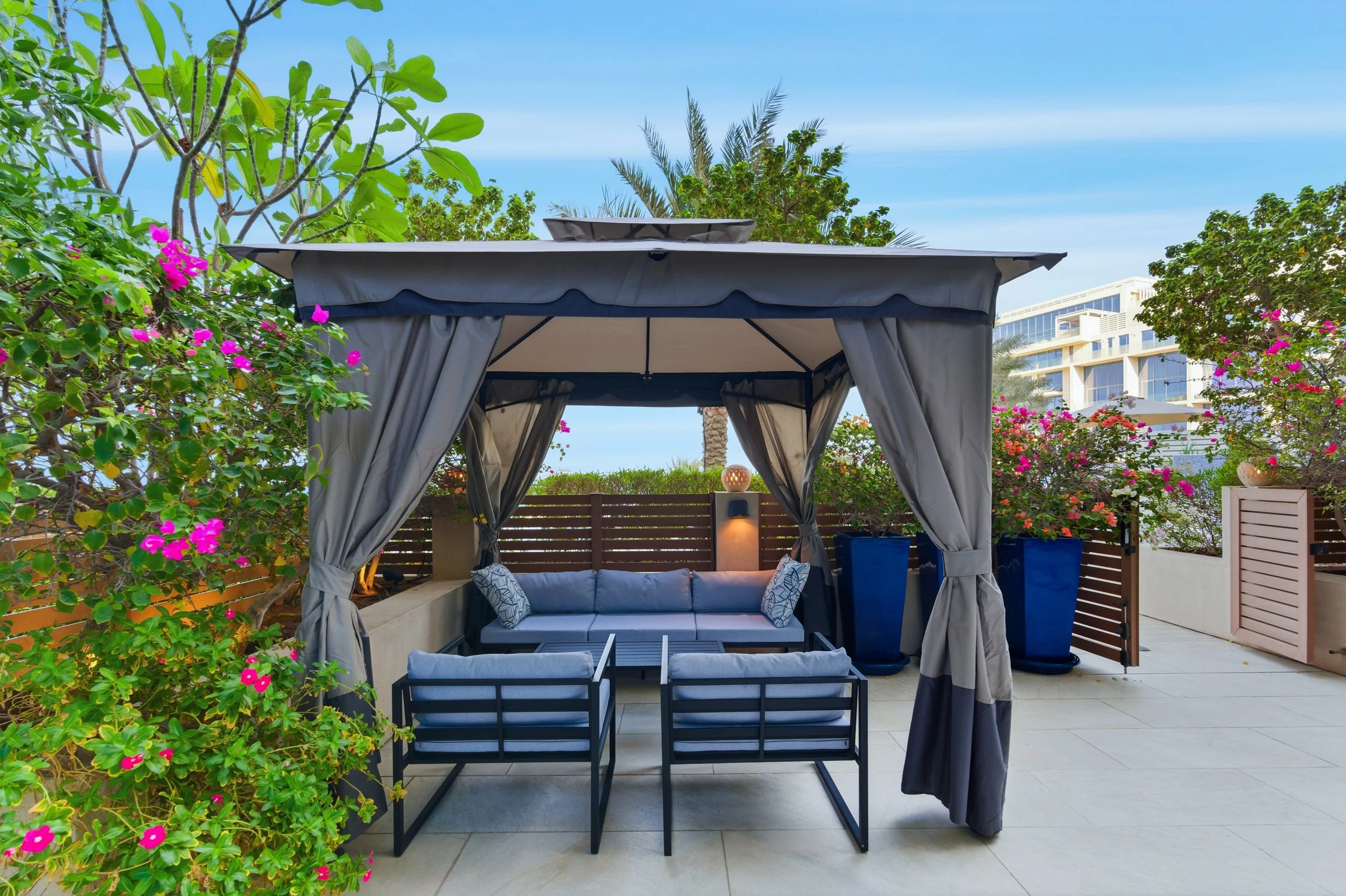 Shaded cabana lounge in a secluded garden setting.
