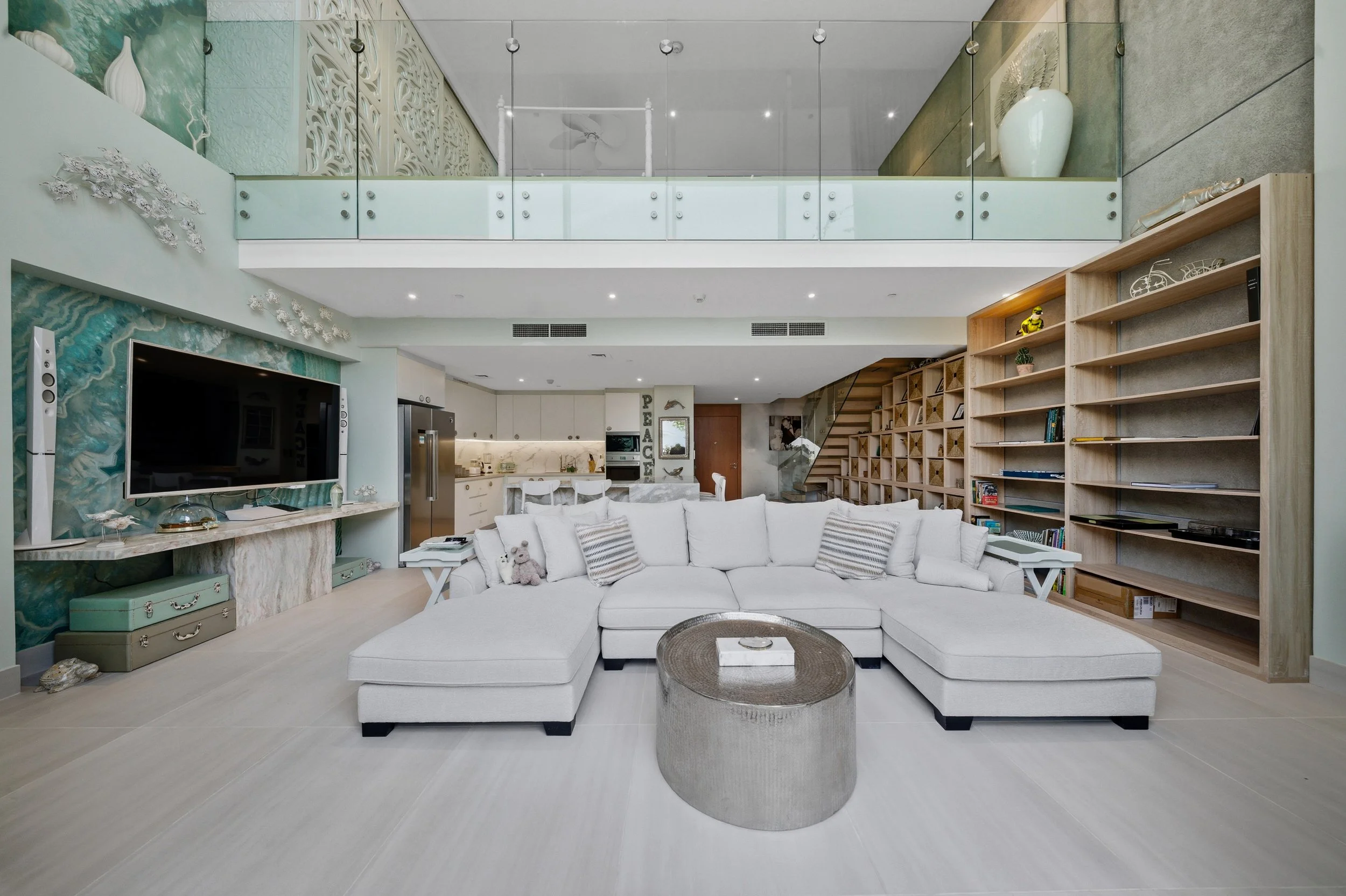 Lofty double-height lounge with comfortable sofa and full entertainment.