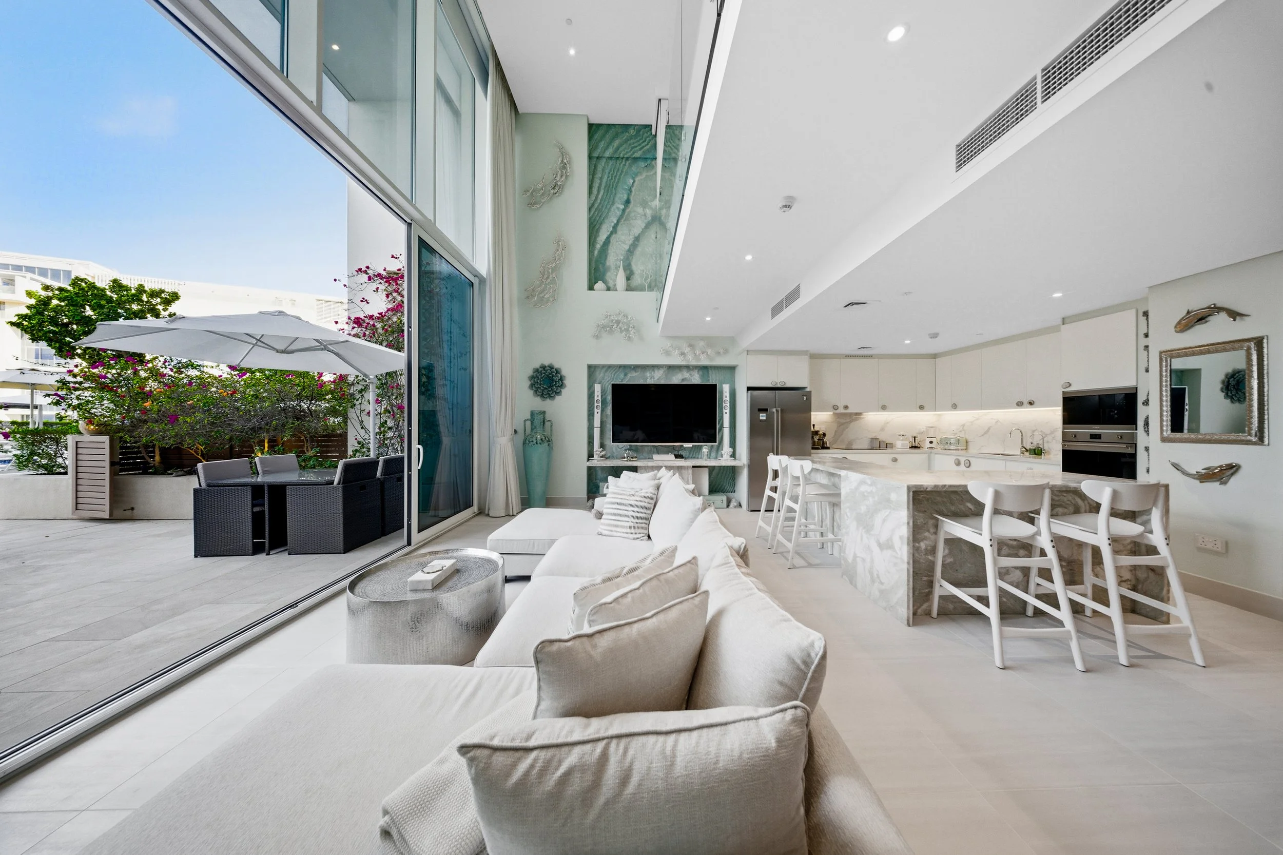 Double-height living area opening to the terrace for an effortless outdoor extension.