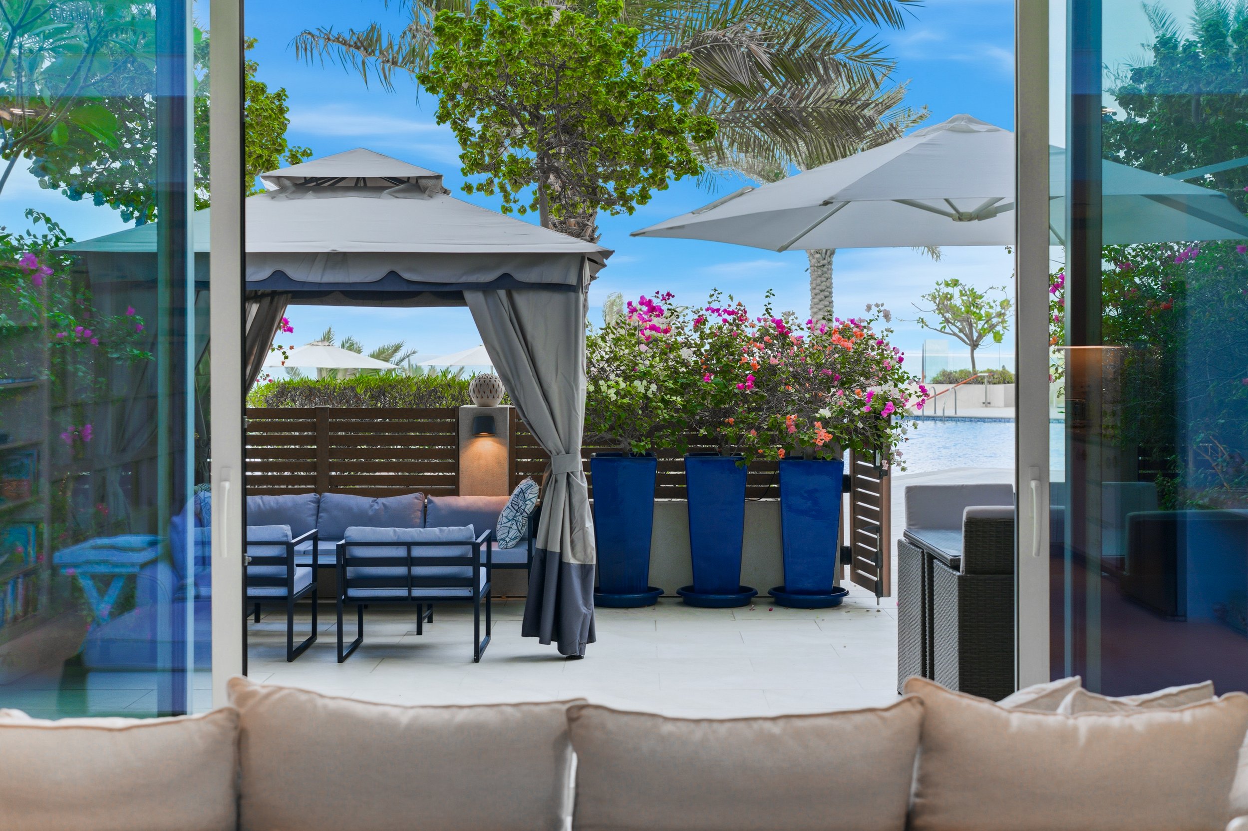 Shaded cabana lounge in a secluded garden setting.