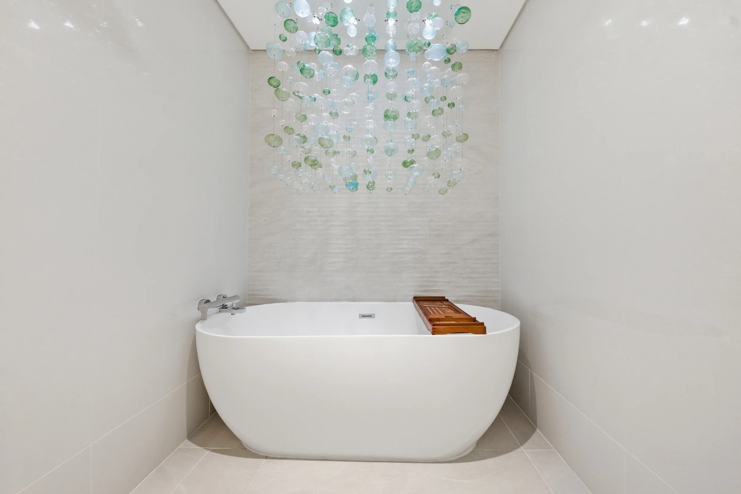 Freestanding bathtub with calming coastal decor.