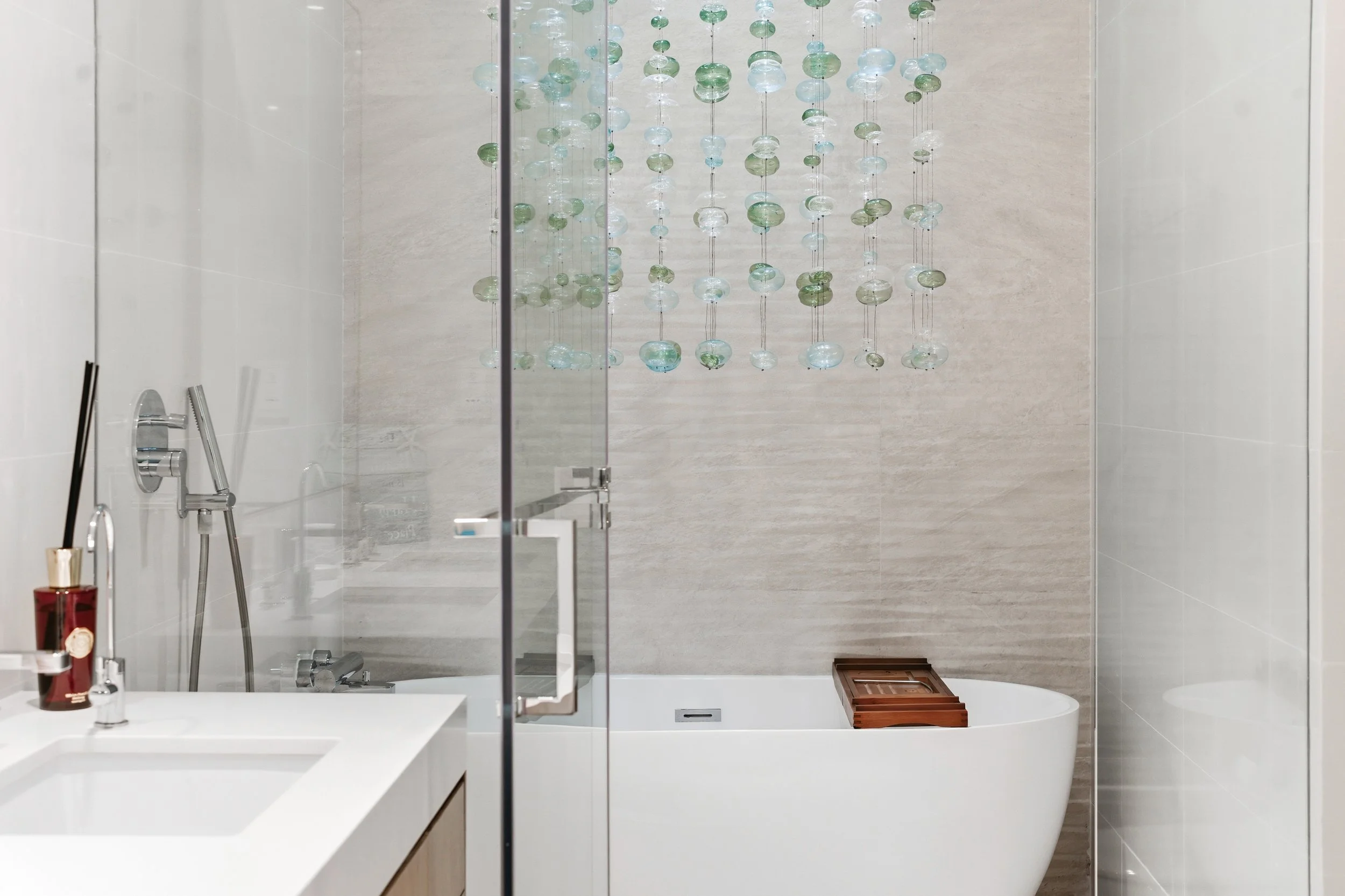 Glass shower with rainfall head and modern finish.