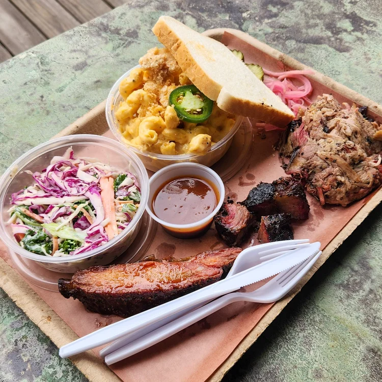A loaded Roux Barbecue tray: ribs, slaw, mac and cheese, pulled pork and sauce
