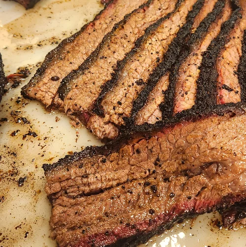 Thick-sliced Angus brisket with a deep pepper bark and smoke ring