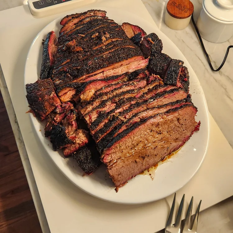 A platter stacked with sliced brisket, ready to serve