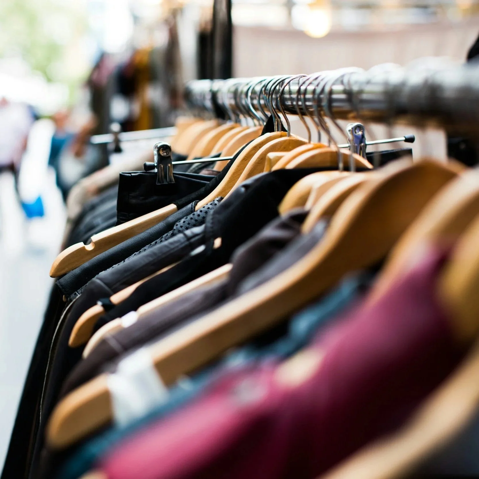 Clothes hanging on a rack in a thrift store or boutique.